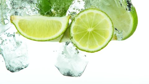 Super slow motion of lime slices falling into water with ice cubes on white. Filmed on high speed cinema camera, 1000 fps.