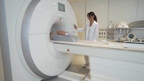 Magnetic resonance imaging, young woman doctor performs a magnetic tomographic examination of a boy, MRI, modern technologies in medicine.