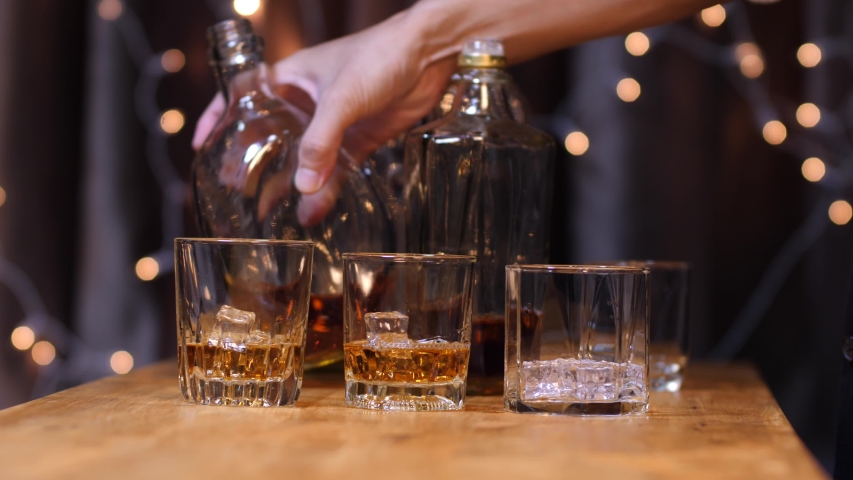 Barman pouring whiskey glass customers sit drink