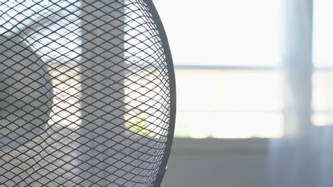 Electric fan for cooling the room in the summer, the heat. Blurred background. Overexposure. High key.