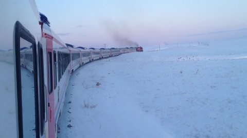 a snowy mountain, the train travels on snowy rails