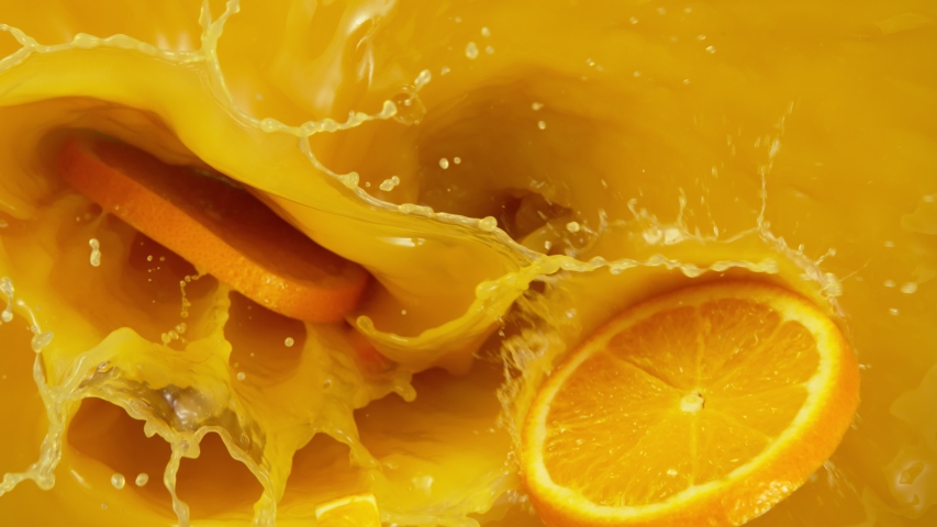 Super slow motion of orange slices falling into juice. Filmed on high speed cinema camera, 1000 fps.