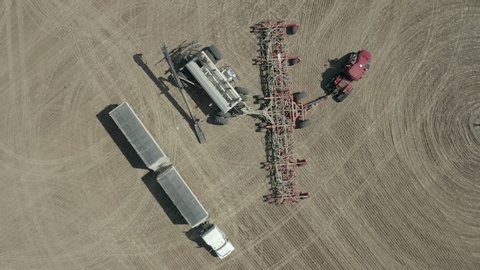 Loading Of Seeds To Seeding Tractor At The Farm In Saskatchewan, Canada - aerial slowmo