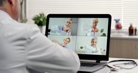 social distancing doctor makes a video call conference with his workteam online,group of doctors talking on livestream chat app greeting with an elbow bump