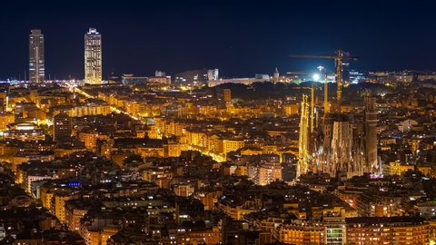 Barcelona, Catalonia, Spain, time lapse view of cityscape including architectural landmark Sagrada Familia Basilica illuminated at night.