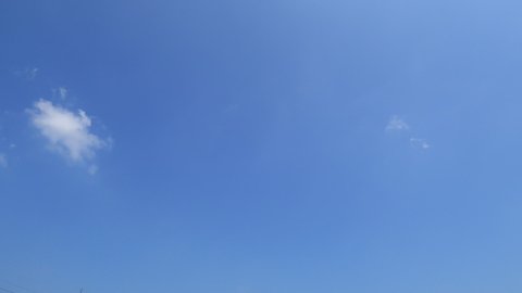 TimeLapse of Sunny clear blue sky background with beautiful minimal white cumulus clouds & fluffy cloudscape rolling on bright daylight  horizon in tropical summer sunlight & sun rays, B-roll footage