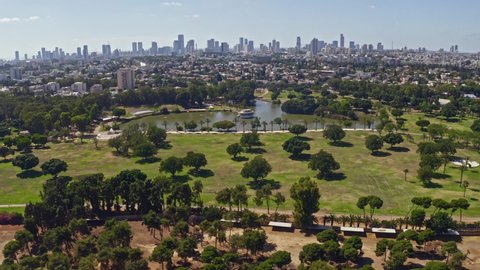 Flying above park "Leumi" in Israel with a distant view on Tel Aviv business skyline, 4k aerial drone footage