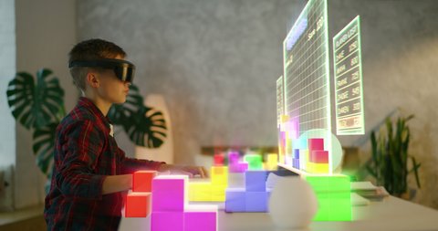 Medium shot of a boy playing VR tetris 3d at home