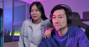 Excited professional cyber sport gamer couple playing in online video game. Overjoyed young asian man and woman winning videogame having fun together give high five celebrating victory at home.