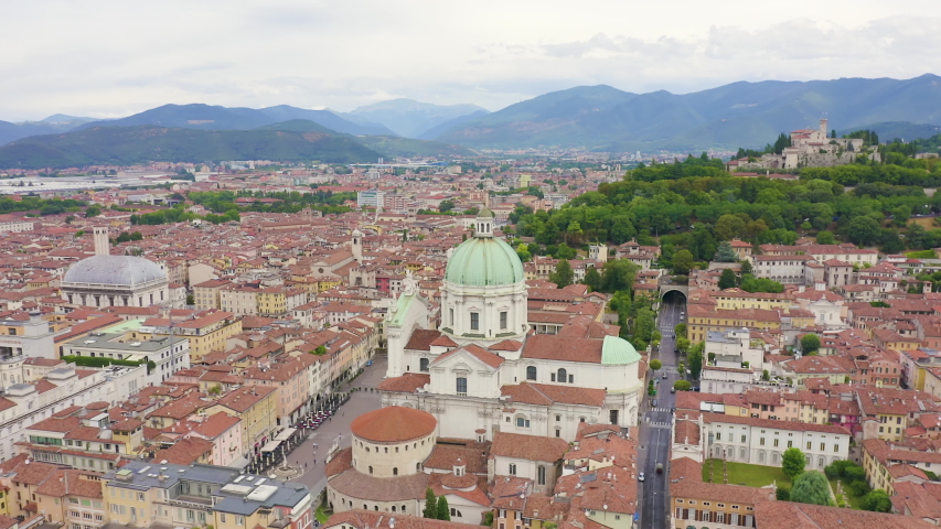 Inscription on video. Brescia, Italy. Cathedral of Santa Maria Assunta. Flight over the city in cloudy weather. Neon white effect text, Aerial View, Point of interest