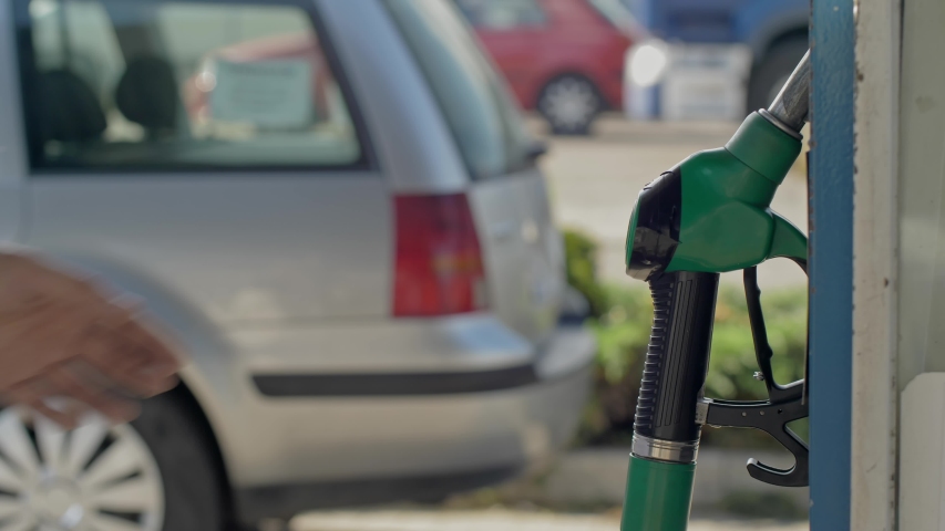 Close up of hand and fuel nozzle. Fuel nozzle getting put into its place.   Fuel, gas station, petrol prices concept. Gasoline, gas, fuel, petroleum concept. Royalty-Free Stock Footage #1055148674