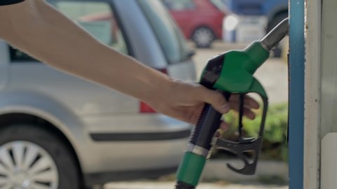 Close up of hand and fuel nozzle. Fuel nozzle getting put into its place.   Fuel, gas station, petrol prices concept. Gasoline, gas, fuel, petroleum concept.