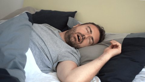 Video about one man snoring loudly in his bed at home