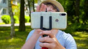 street portrait of a modern teenager.cheerful positive boy blogger talking on a smartphone on the outdoors on a sunny summer day