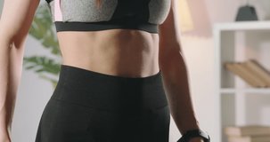 Close up shot of fit girl measuring her perfect waist. Female athlete losing extra weight after keeping a diet and doing sports - motivation concept 4k footage