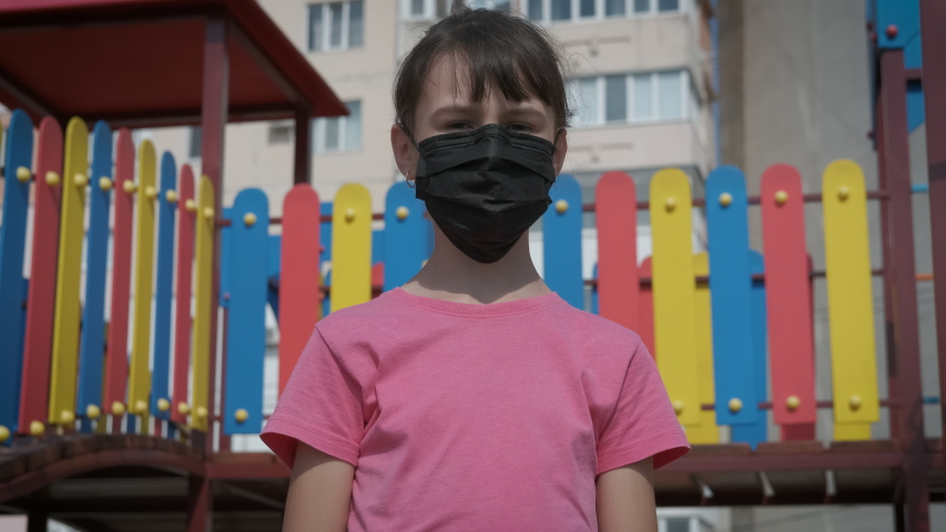 Stop mask mode. A sad teen in protective mask show stop coronavirus on playground.