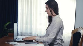 Young business woman typing on laptop computer working in internet, beautiful female professional user lady using pc technology doing online job in office or browsing web sit at home table