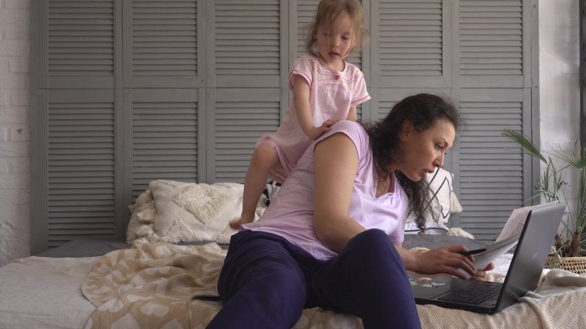 A multitasking mom working remote is stressed out. Problems associated with work at home. Noisy active child playing. Telecommute Job | Shutterstock HD Video #1055179061