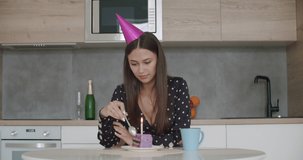Young woman in party cap eating cake, having online birthday party with friends. Girl speaking looking at camera making video chat, lifestyle blog vlog, webcam view. Stay home, quarantine concepte.
