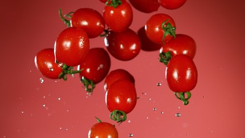 Super slow motion of falling tomatoes with water splashes. Filmed on high speed cinema camera, 1000fps