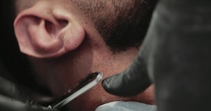 Men's haircut in a barbershop. Shaving with a dangerous razor. High quality 4k footage