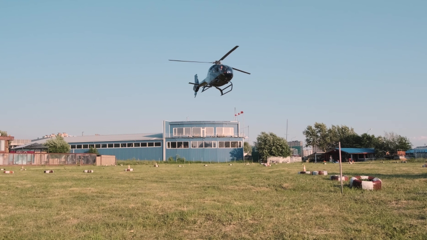 Dark blue helicopter landing in a sunny day