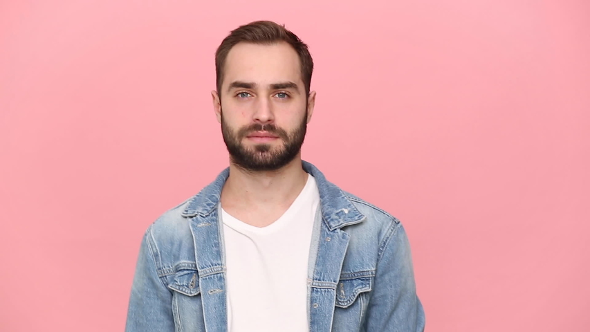 Young angry man guy 20s years old in denim jacket white t-shirt isolated on pastel pink background studio. People lifestyle concept. Looking at camera showing stop gesture crossed folded hands palm Royalty-Free Stock Footage #1055184275