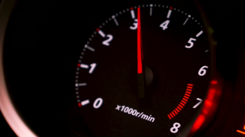 Close up of car speed meter. Footage. Interior of a modern car, dashboard with an engine speed dial and moving red arrow. Royalty-Free Stock Footage #1055186474