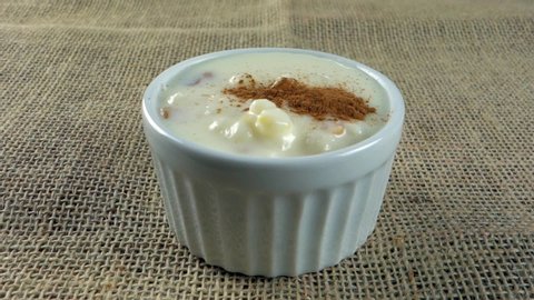 corn hominy with peanuts and cinnamon. Typical Brazilian dessert, aka Canjica, made with corn hominy, milk, coconut milk, condensed milk, sour cream, powdered milk, peanuts and cinnamon.