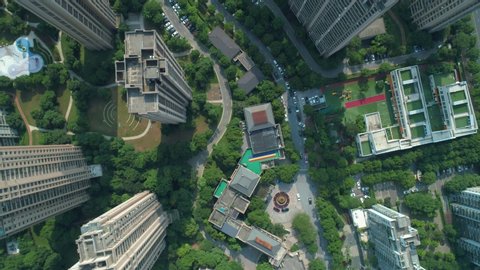 Aerial drone shot over residential apartment buildings on sunny day. Aerial shot over community apartment complex in China.