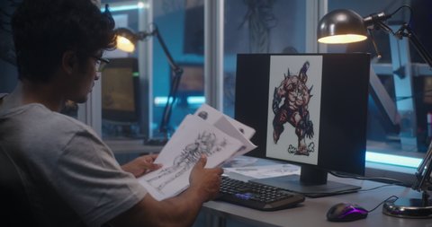 Medium shot of a male graphic designer sorting concept art for video game