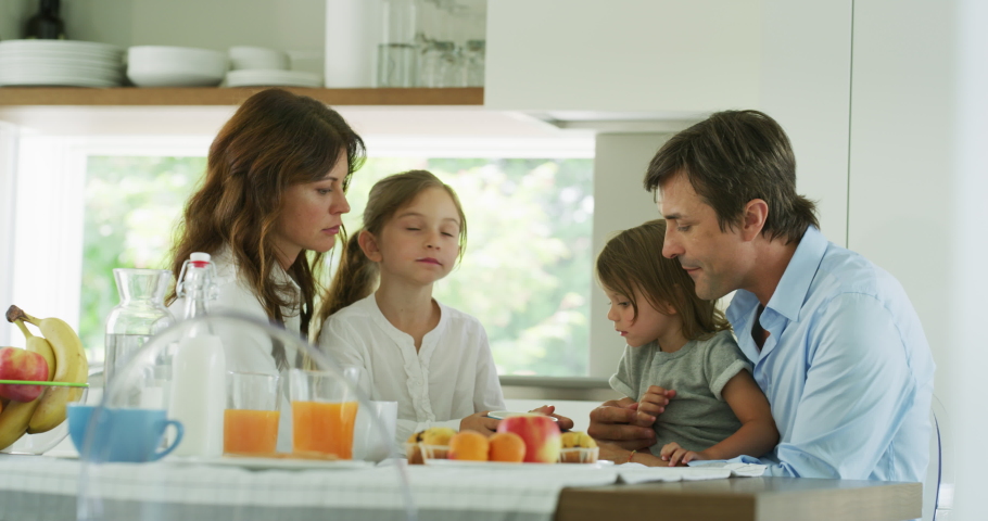 Authentic shot of a happy smiling family is enjoying their time together while having a breakfast in a kitchen at home in the morning. Royalty-Free Stock Footage #1055209313