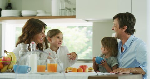 Authentic shot of a happy smiling family is enjoying their time together while having a breakfast in a kitchen at home in the morning.