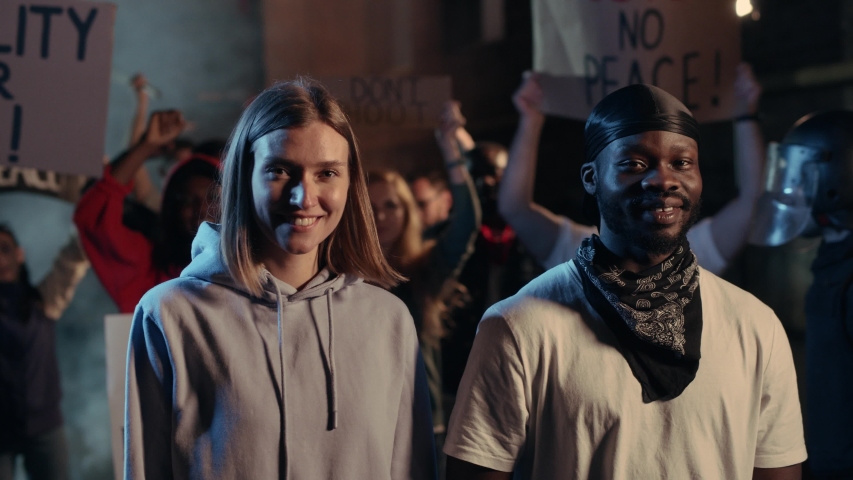 Black Lives Matter. Human Equality. Friendly Happy Smiling Mixed-Race Couple Hugging on the Protest. Freedom Demonstration Rally of Diverse Activists Protesting. Royalty-Free Stock Footage #1055212532