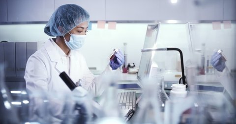 Asian scientist working with biohazardous sample. Futuristic laboratory equipment