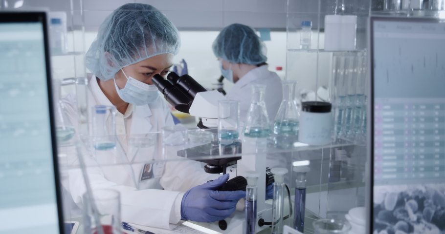 Female doctor working with pathogen samples. Using microscope Royalty-Free Stock Footage #1055215874
