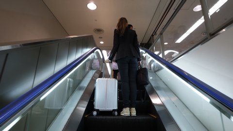 NARITA, JAPAN - APRIL 02, 2018: Passenger woman (model released) arrive to Japan, walk to passport control at Narita International Airport. First person view camera follow behind