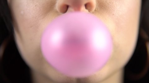 young woman blowing bubble and chewing bubble gum, pink lips. 4k. Slow motion