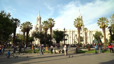 AREQUIPA, PERU. DEC 2019. Panoramic view of the main square and the Cathedral of Arequipa on a sunny day. Some people stroll and have fun in the plaza.