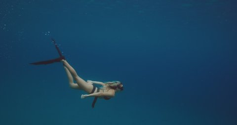 Beautiful woman swimming underwater free diving, outdoor adventure lifestyle