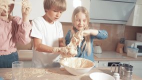Children learn to cook the dough for the pie, mix the dough with their hands.