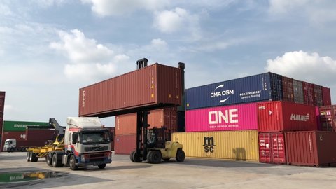 KLANG, MALAYSIA - JULY 2, 2020: Container hyster also known as container handler shifting container at container yard and seaport terminal. Logistics operation.
