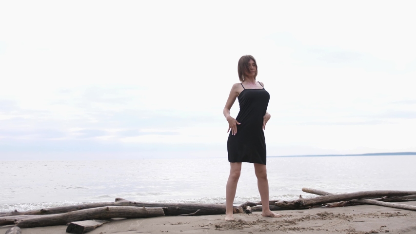 Young beautiful woman dancing on the seashore. slow motion