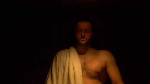 Men Relaxing in Sauna, close up , breathing slowly with towel on shoulder
