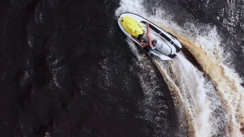 A young man is enjoying life while riding on a personal watercraft. The concept of relaxation and a healthy lifestyle. Aerial view