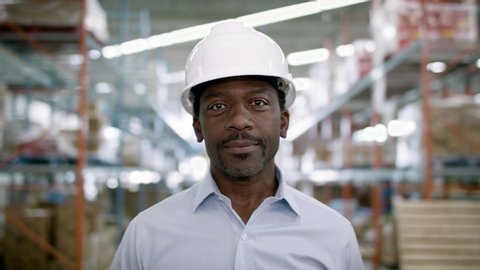 Portrait of a frontline essential worker in a warehouse. Shot in slow-motion and 4k. 