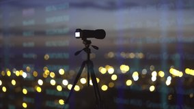 The camera with tripod stand by cityscape holographic background
