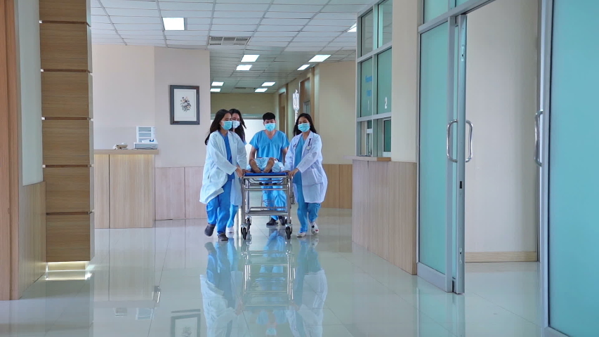 Emergency Department in the Hospital,Doctors, Nurses Running through the Hallway, in a Hurry to Save Lives a patient on a gurney to the operating theater, as seen from the patient's point of view. Royalty-Free Stock Footage #1055276996
