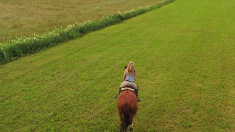 
Woman rides a horse in the green grasslands of Grono (GR) Switzerland