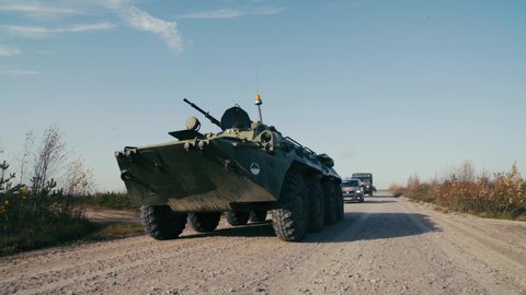 Russian military police patrol the area. A military column of armored vehicles rides through a picturesque landscape. Outdoor front view of armored carrier driving. 